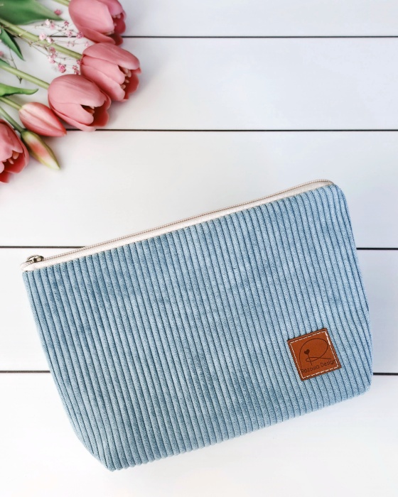 sztruksowa kosmetyczka zamykana na zamek w kolorze jasno niebieskim