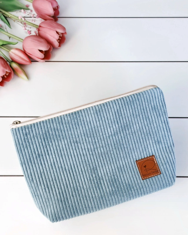 sztruksowa kosmetyczka zamykana na zamek w kolorze jasno niebieskim